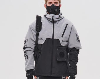 May include: A futuristic-style outfit in gray and black. The ensemble includes a hooded jacket, cargo pants, and a face mask. The jacket has a two-tone design with pockets and graphic details. The pants feature straps and multiple pockets. The outfit is completed with black gloves and boots.