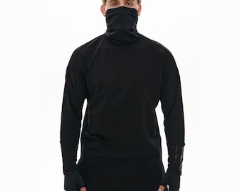 May include: Black long-sleeve shirt with a high neck and attached face covering. The shirt has fingerless gloves and a design on the sleeves. The model is wearing black pants. The background is white.