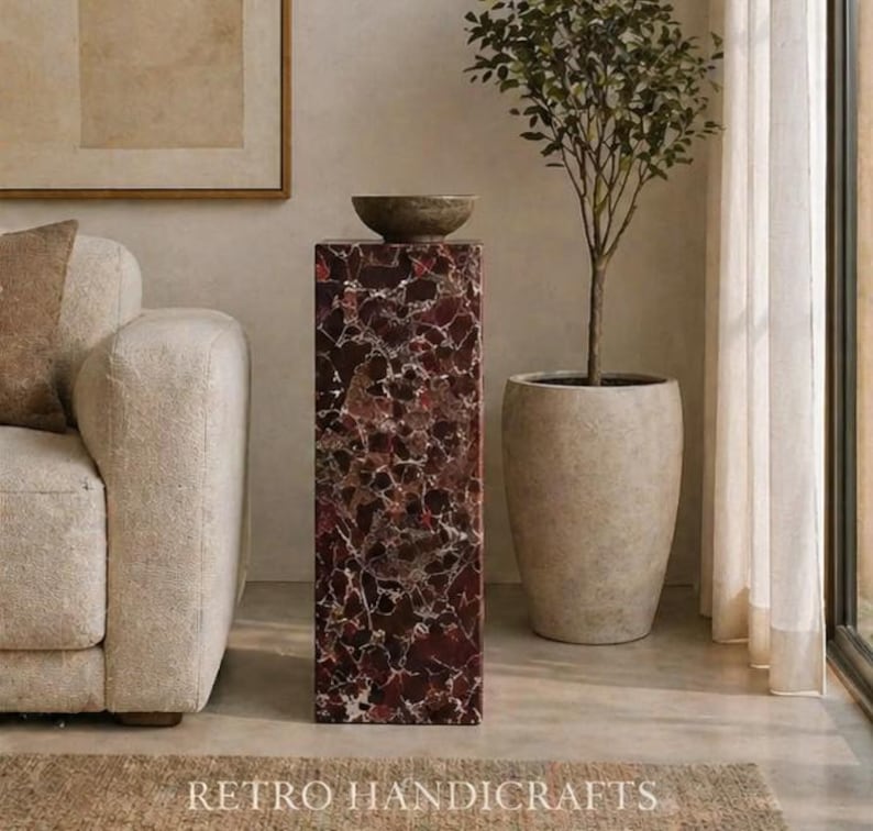 May include: A tall, rectangular pedestal with a dark red and white speckled pattern, topped with a small, round, gray bowl. A potted tree and a beige sofa are in the background. The text "RETRO HANDICRAFTS" is at the bottom.