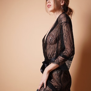 K&ouml;nnte beinhalten: Eine schwarze Spitzenrobe mit einem Satinband. Die Robe ist durchsichtig und hat ein zartes Blumenmuster.
