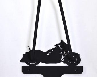 Könnte beinhalten: Schwarze Metall-Wandkunst mit Motorrad-Silhouette. Das Kunstwerk zeigt ein detailliertes Motorrad-Design mit einem gebogenen Oberteil und einer unteren Halterung. Das Motorrad ist im Profil dargestellt und zeigt seine Räder, den Motor und den Lenker.