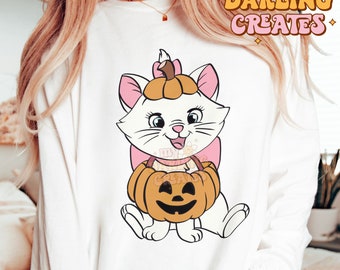 May include: White sweatshirt with a cartoon image of a white cat wearing a pumpkin hat and holding a pumpkin. The cat is smiling and has pink ears and a pink bow. The text "my darling creates" is in the top right corner of the image.