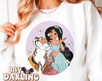 May include: A white sweatshirt with a purple circle design featuring a cartoon image of Jasmine from Aladdin, Rajah the tiger, and Abu the monkey. The design also includes white flowers and the text "My Darling Creates".