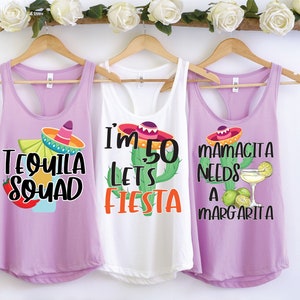 Könnte beinhalten: Drei lila Tanktops mit verschiedenen Sprüchen. Das erste Tanktop sagt "Tequila Squad" mit einem Sombrero und einem Margarita-Glas. Das zweite Tanktop sagt "Ich bin 50, lass uns feiern" mit einem Kaktus und einem Sombrero. Das dritte Tanktop sagt "Mamacita braucht eine Margarita" mit einem Kaktus und einem Margarita-Glas.