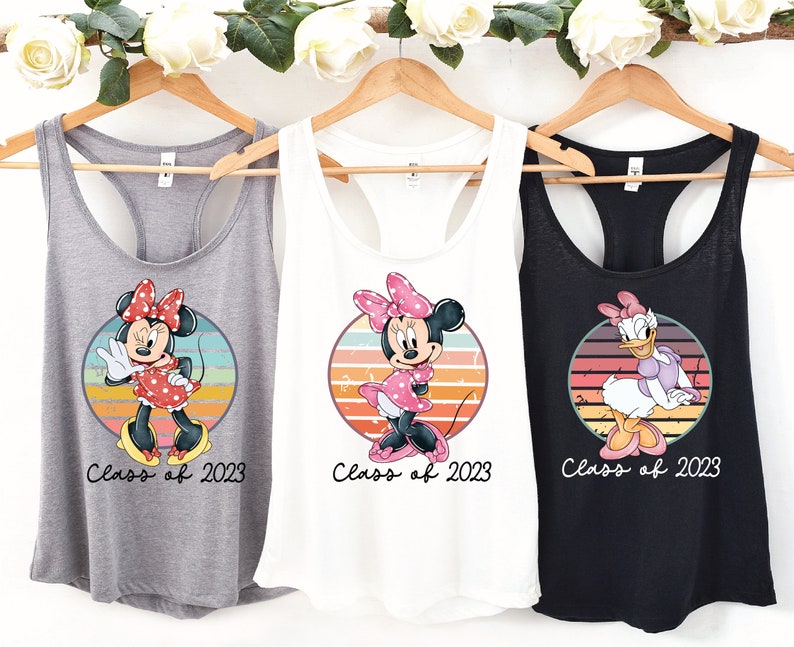 May include: Three tank tops with different Disney characters. The first tank top is gray with a vintage-style image of Minnie Mouse and the text "Class of 2023". The second tank top is white with a vintage-style image of Minnie Mouse and the text "Class of 2023". The third tank top is black with a vintage-style image of Daisy Duck and the text "Class of 2023".