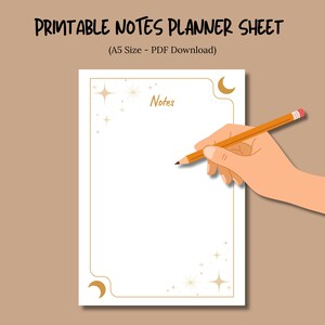 May include: Printable notes planner sheet with gold celestial accents. The white A5-sized PDF download features a decorative border with stars and crescent moons. A hand holds a pencil, ready to write on the "Notes" page.