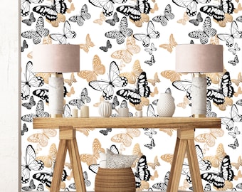 May include: A white wall with a gold and black butterfly pattern wallpaper. Two lamps with white shades are on a wooden table with a brown woven basket and a white pillow.