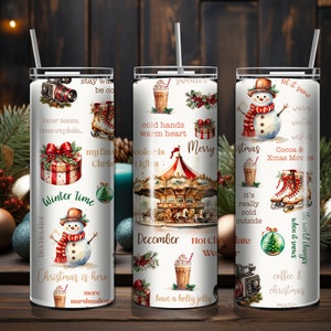 May include: Three white stainless steel tumblers with various Christmas-themed designs. The designs include a snowman, a carousel, a gift box, a Christmas tree, and a cup of hot chocolate. The tumblers have text that reads "Winter Time", "Merry Christmas", "Let it snow", "Hot Chocolate", "Cocoa & Xmas Movies", "The world changes when it snows", "Coffee & Christmas", "Dear Santa, I can explain", "My favourite colour is Christmas Lights", "It's really cold outside", "Have a holly jolly", "Christmas is here", "More marshmallows".