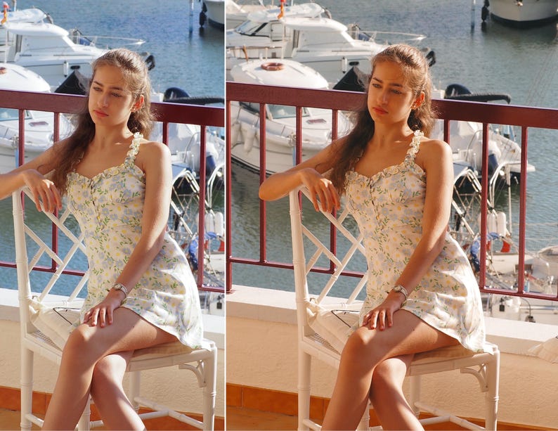 May include: A young person wearing a white floral dress with a ruffled neckline sits on a white wicker chair. The person is looking off to the side and has long brown hair. The chair is on a balcony overlooking a marina with boats in the water.