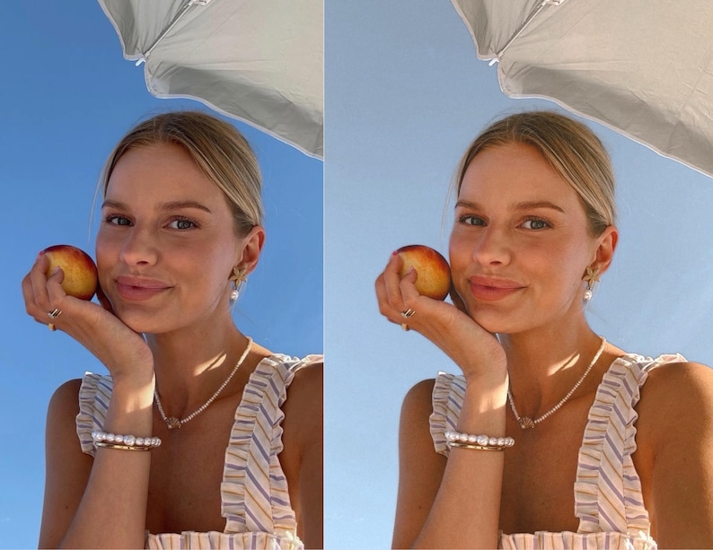 May include: A woman with blonde hair is holding a peach in her hand. She is wearing a striped top and a pearl necklace. She is smiling at the camera.