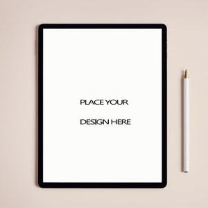 May include: A white tablet computer with a black frame and a white pen on a light pink background. The text "PLACE YOUR DESIGN HERE" is displayed on the screen.