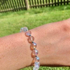 May include: A bracelet made of iridescent clear beads with dark blue accents.