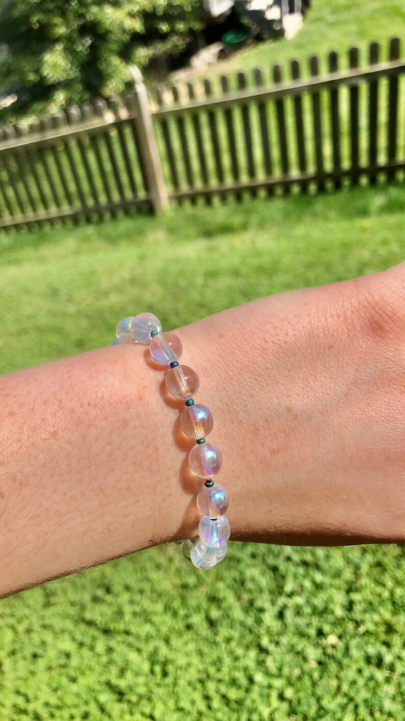 May include: A bracelet made of iridescent clear beads with dark blue accents.