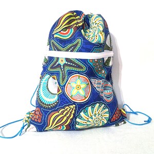 May include: A blue drawstring backpack with a white rim and blue drawstrings. The bag is patterned with colorful starfish, seashells, and other sea life. The bag is made of fabric.