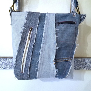 May include: A patchwork denim crossbody bag with a zipper pocket and a long adjustable strap. The bag is made from various shades of blue denim, with raw edges and a metal zipper.