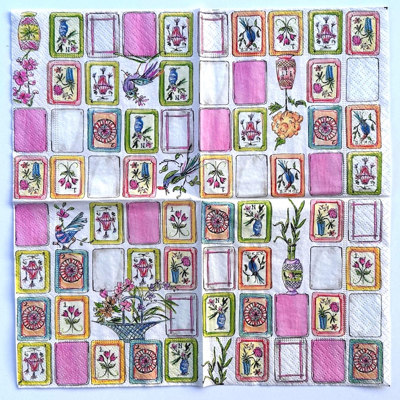May include: A decorative paper napkin with a repeating pattern of framed illustrations and pink squares. The illustrations feature birds, flowers, and vases in a variety of colors, including pink, green, and blue. The napkin is white with a textured surface.