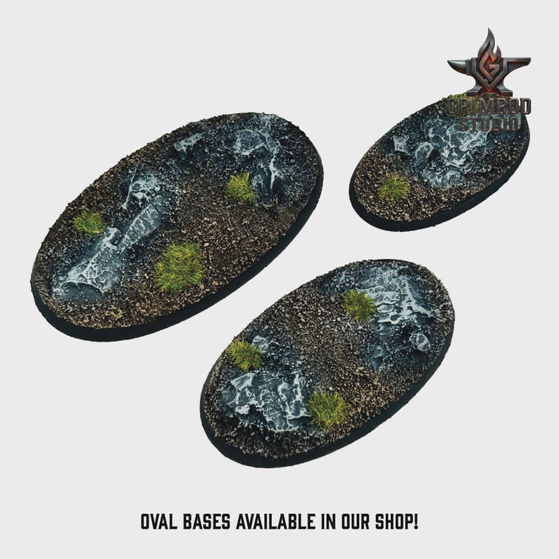 May include: Three oval-shaped miniature bases with textured surfaces, featuring a mix of dark gray, brown, and green elements. The bases have a rocky appearance with patches of green vegetation. Text at the bottom reads: OVAL BASES AVAILABLE IN OUR SHOP!