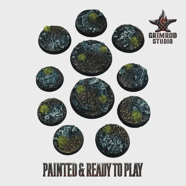 May include: A collection of ten circular, textured bases for miniature figures, painted with a rocky terrain and patches of green vegetation. The bases vary in size and are ready to use. The text "PAINTED & READY TO PLAY" is at the bottom.