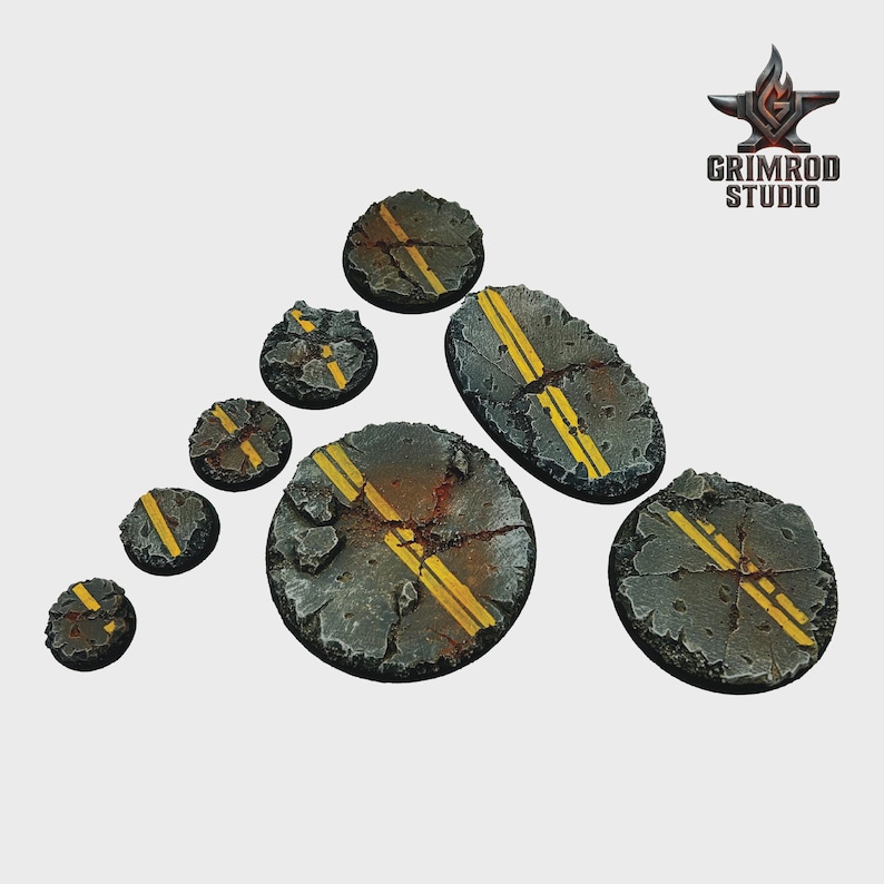 May include: A collection of miniature terrain bases, featuring a distressed asphalt design with yellow road markings. The bases vary in size and shape, with a cracked and weathered appearance. The Grimrod Studio logo is visible in the upper right corner.