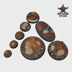 Pu&ograve; includere: Una collezione di sette basi strutturate, circolari e ovali, con un'estetica industriale arrugginita. Le basi presentano ingranaggi incorporati, griglie metalliche e una variet&agrave; di trame. Il logo Grimrod Studio si trova in alto a destra.
