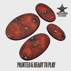 Puede incluir: Cuatro bases ovaladas texturizadas de color marrón rojizo, con pequeñas rocas y detalles óseos. Las bases están pintadas y listas para jugar, con el logotipo de Grimrod Studio en la esquina superior derecha. El texto en la parte inferior dice "PAINTED & READY TO PLAY."