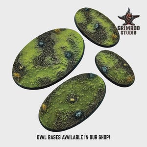 May include: Four oval bases with a textured, grassy terrain. The bases feature a mix of green, brown, and tan colors, with small rocks and patches of vegetation. The text "OVAL BASES AVAILABLE IN OUR SHOP!" is at the bottom.