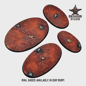 May include: Four oval-shaped miniature bases with a textured, reddish-brown surface. Each base features small, embedded details like rocks and a skull or insect. The bases are for miniature gaming. Text: OVAL BASES AVAILABLE IN OUR SHOP!
