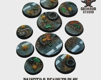 May include: A collection of painted miniature bases, each circular with a road and terrain design. The bases feature asphalt, grass, and debris, with some including tires and mechanical parts. The text "PAINTED & READY TO PLAY" is visible.