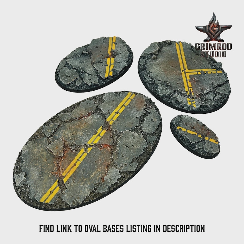 May include: Four oval-shaped miniature bases with a cracked asphalt design. Each base features yellow road markings, simulating a section of a road. The bases are designed for miniature figures and tabletop gaming.