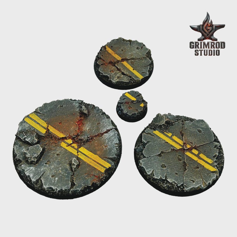 May include: Four circular bases with a cracked asphalt design, featuring yellow road lines. The bases vary in size, with the largest measuring approximately 2 inches in diameter. The Grimrod Studio logo is in the upper right corner.