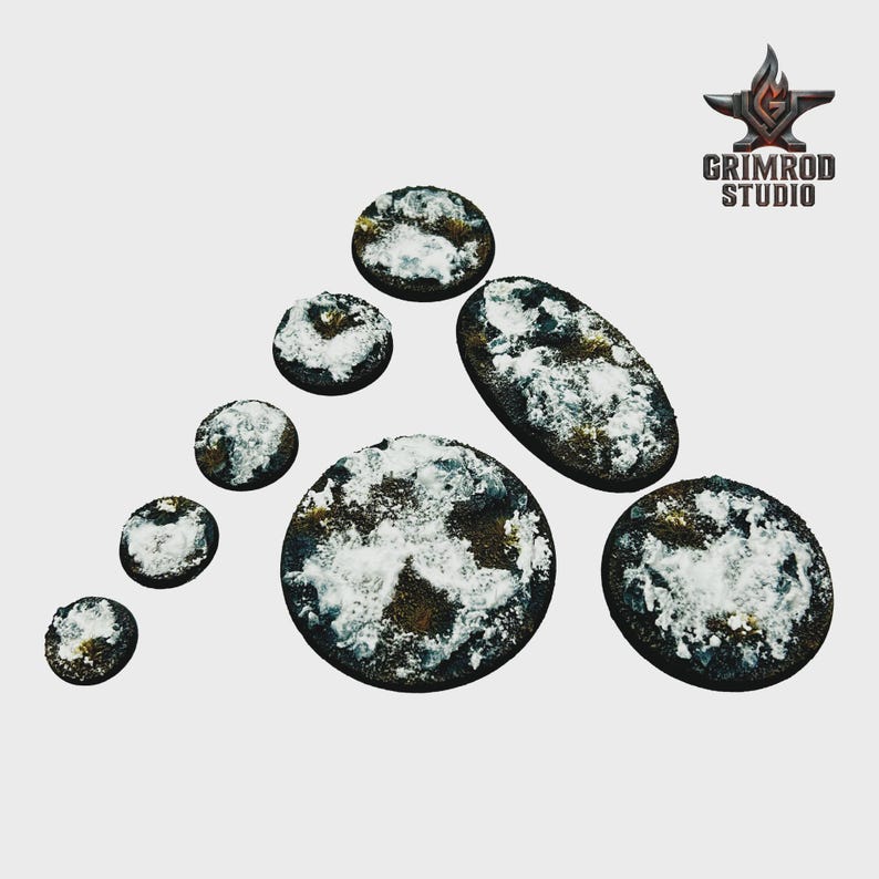 May include: A collection of miniature bases in various shapes, including round and oval, with a textured, dark brown surface and patches of white. The Grimrod Studio logo is in the upper right corner.