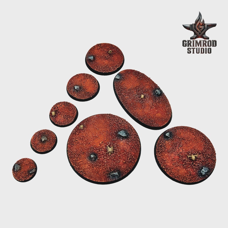 May include: A collection of textured, reddish-brown miniature bases in various shapes and sizes. Each base features embedded stones and small details, with the "Grimrod Studio" logo in the upper right corner.