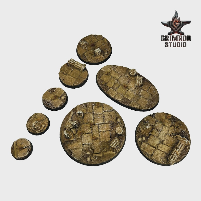 May include: A collection of miniature bases in various shapes and sizes. The bases are textured with a cobblestone pattern and are painted in shades of brown and tan, with small architectural details.
