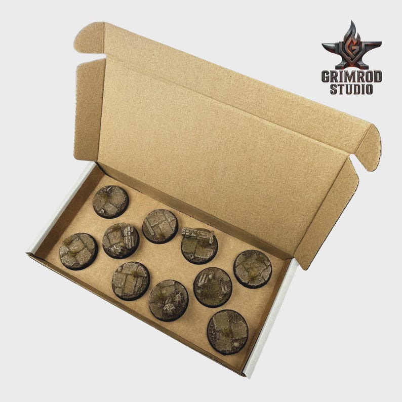 May include: A cardboard box containing ten round, textured bases for miniature figures. The bases are primarily brown with detailed, weathered designs. The Grimrod Studio logo is visible in the upper right corner.