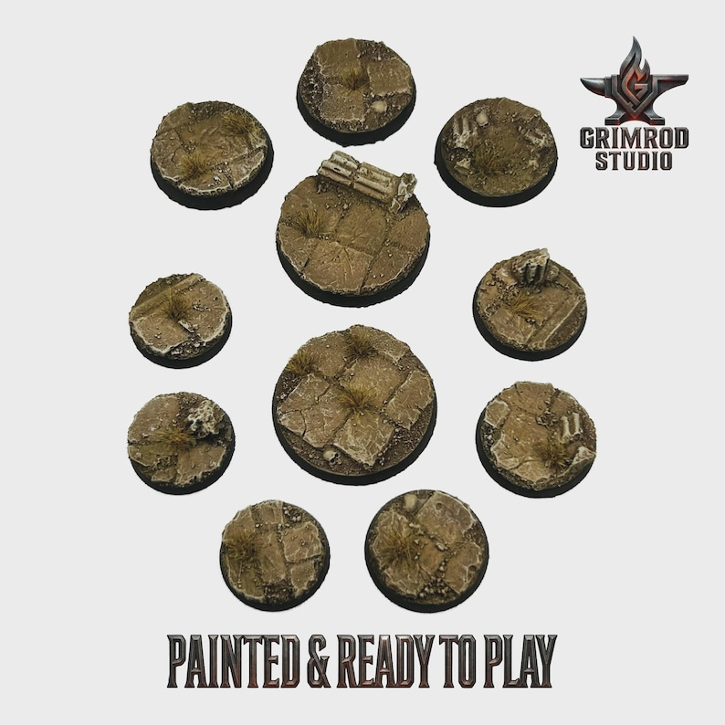 May include: A collection of ten circular, textured bases, painted in shades of brown and tan, with patches of green. The bases are designed to look like a stone surface with grass and debris. The text "PAINTED & READY TO PLAY" is visible.