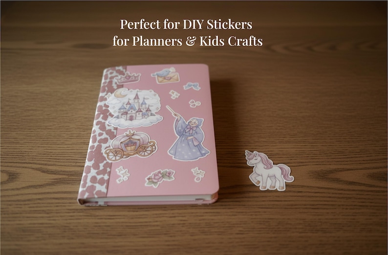 Op de afbeelding: Een roze notitieboek met stickers van een kasteel, koets en fee. Een eenhoornsticker staat naast het notitieboek. Het notitieboek heeft een koeienprint op de randen. De tekst bovenaan luidt "Perfect for DIY Stickers for Planners & Kids Crafts."