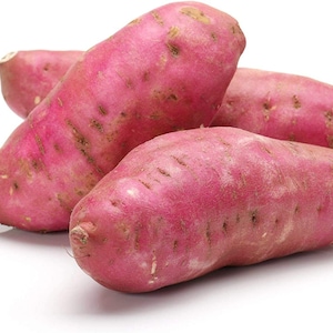 Könnte beinhalten: Vier rohe Süßkartoffeln mit rot-violetter Schale liegen auf einem weißen Hintergrund.