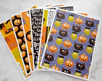 Pode incluir: Um conjunto de seis papéis de embrulho temáticos de Halloween. Os papéis apresentam uma variedade de designs, incluindo abóboras, gatos e monstros. Os papéis são impressos em cartão branco e têm um acabamento brilhante.