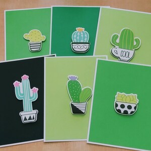 May include: Set of six green cards with different cactus illustrations. Each card features a cactus in a pot with a unique design. The cards are perfect for adding a touch of whimsy to any space.