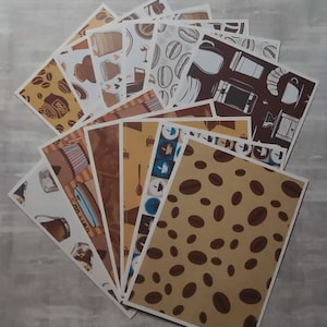 May include: A collection of 12 different patterned paper sheets featuring coffee beans, coffee cups, coffee makers, and other coffee-themed designs. The papers are all white with brown, black, and blue accents.