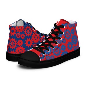 Peut inclure: Une paire de baskets montantes en toile avec un motif d'engrenages rouge et bleu. Les chaussures ont des lacets noirs et une semelle noire.