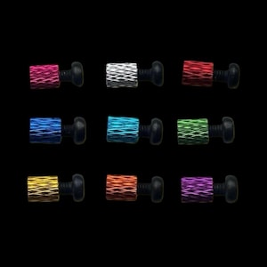 May include: Assortment of ten colorful, textured, metal screws with black plastic heads. The screws are in various colors, including red, white, blue, teal, green, gold, orange, and purple.