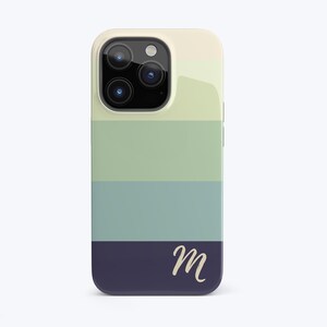 May include: A white, green, blue, and dark blue striped phone case with the letter "M" in a cream color on the bottom stripe.