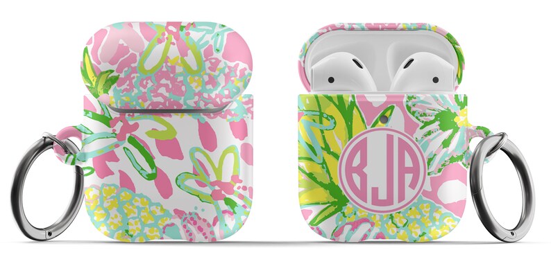 May include: A pink, green, and yellow floral patterned Airpods case with a silver keychain and a pink circle with the monogram "BJA" in white.