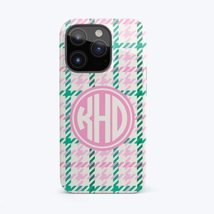 May include: A pink and green plaid phone case with a white circle containing the monogram "KHD" in pink.