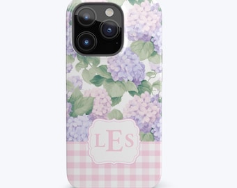 Puede incluir: Una funda de teléfono de cuadros vichy rosa y blanco con un diseño floral y el monograma "LES" en un marco blanco.