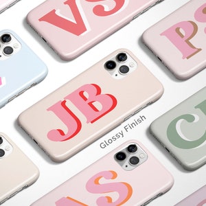 May include: A collection of personalized phone cases with various colors and initials. The cases have a glossy finish and feature a bold, layered font style.