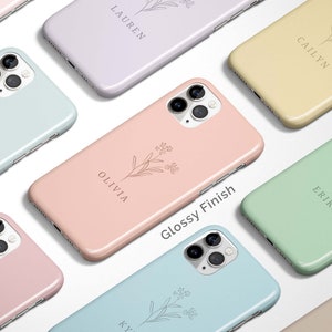 May include: Nine different phone cases with a floral design and a name printed on each case. The cases are in various colors, including pink, blue, green, and yellow. The cases have a glossy finish.
