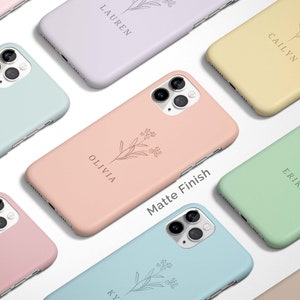 May include: A collection of phone cases with a floral design and personalized names. The cases are available in a variety of colors, including pink, blue, green, and yellow. The text "Matte Finish" is printed on one of the cases.