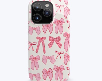 May include: A white iPhone case with a pink bow pattern. The case has a camera cutout and a white background.